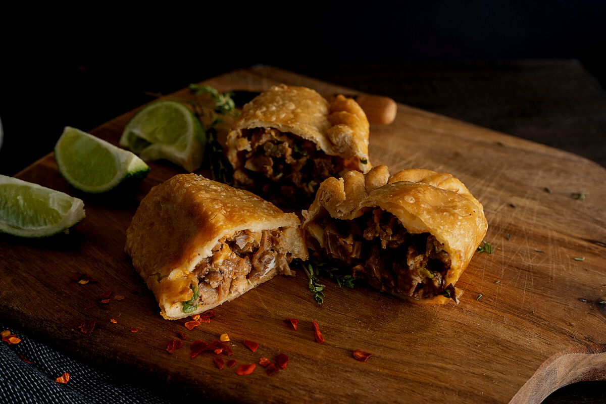 Sliced Fried Empanadas with Lime Wedges